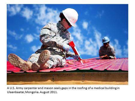 A U.S. Army carpenter and mason seals gaps in the roofing of a medical building in Ulaanbaatar, Mongolia. August 2011.