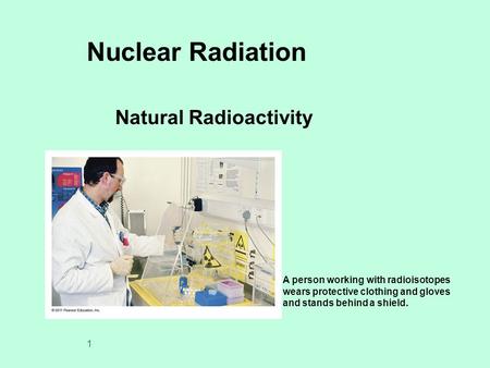 1 Nuclear Radiation Natural Radioactivity A person working with radioisotopes wears protective clothing and gloves and stands behind a shield.