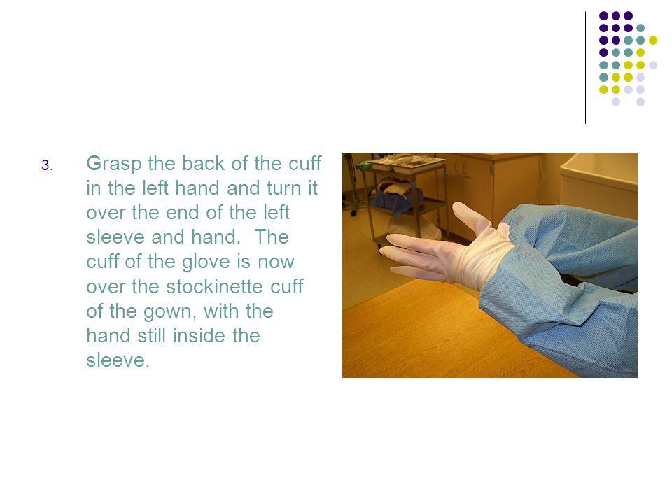 Grasp the back of the cuff in the left hand and turn it over the end of the left sleeve and hand.