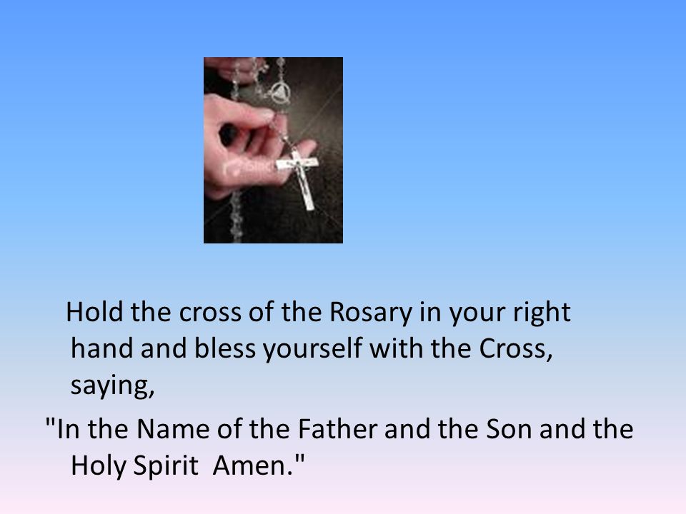 Hold the cross of the Rosary in your right hand and bless yourself with the Cross, saying, In the Name of the Father and the Son and the Holy Spirit Amen.