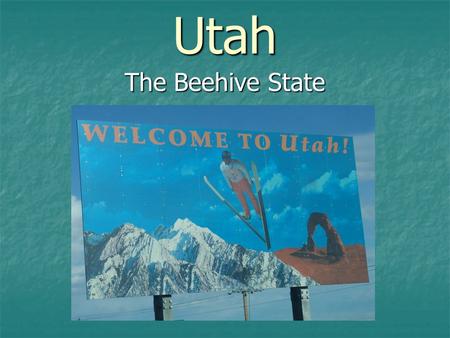 Utah The Beehive State. On a blue field, appears the state seal. In the center of the seal is a beehive, the state emblem, with a sego lily growing on.