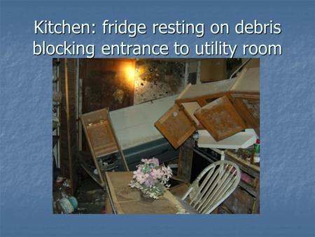 Kitchen: fridge resting on debris blocking entrance to utility room.
