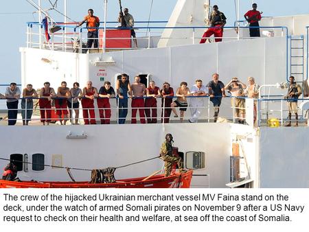 The crew of the hijacked Ukrainian merchant vessel MV Faina stand on the deck, under the watch of armed Somali pirates on November 9 after a US Navy request.