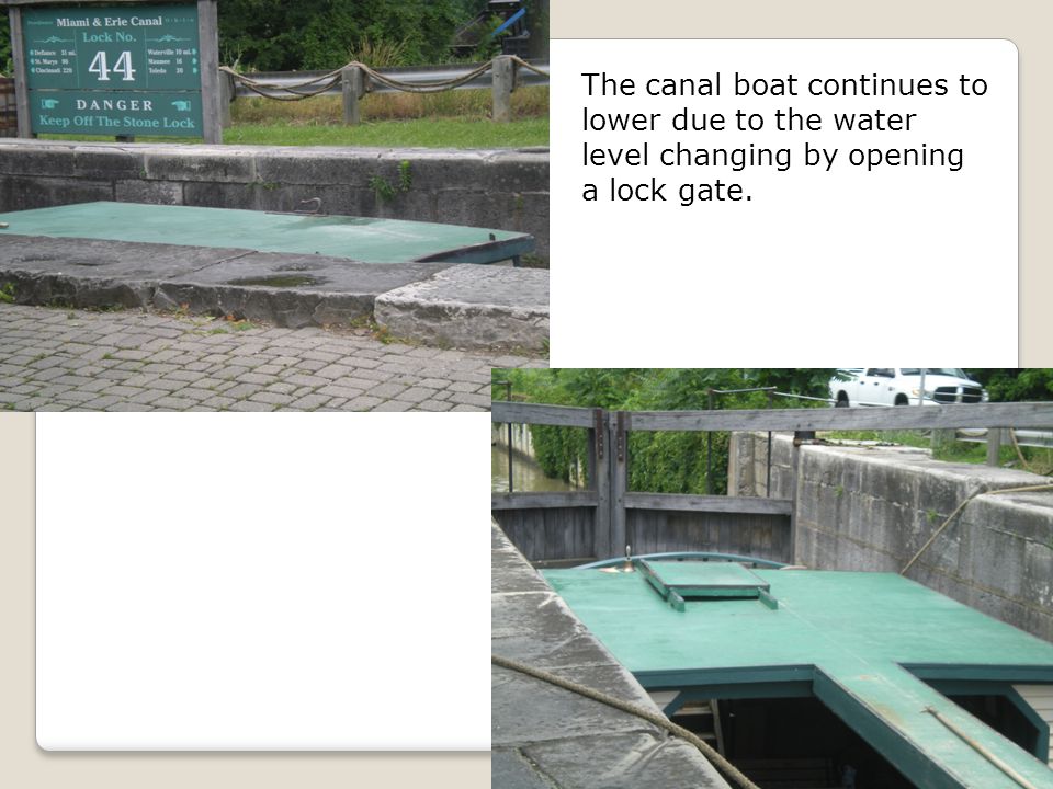 The canal boat continues to lower due to the water level changing by opening a lock gate.
