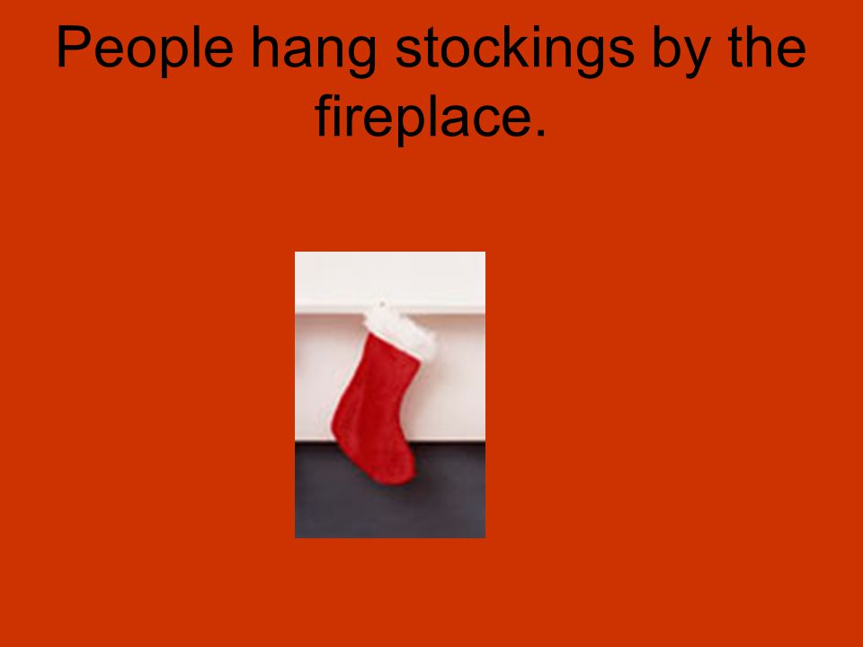 People hang stockings by the fireplace.